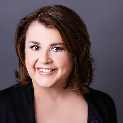 Headshot of Bethanne Patrick, a smiling White woman in a black top