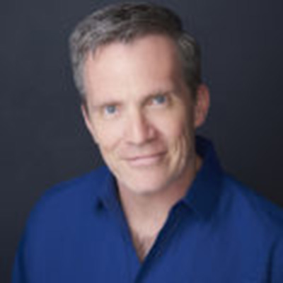 Headshot of Louis Bayard, a White man wearing a blue collared shirt