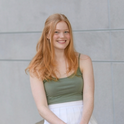 Headshot of a smiling White woman with long hair wearing a green top