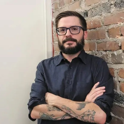 Headshot of author Brian Castleberry, a White man wearing glasses and a dark collared top