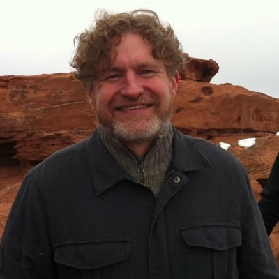 Headshot of author Brian Evenson, a smiling White man wearing a dark jacket