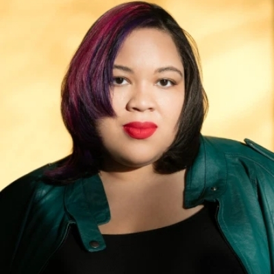 Headshot of author Danielle Evans, a Black woman wearing red lipstick and a green top