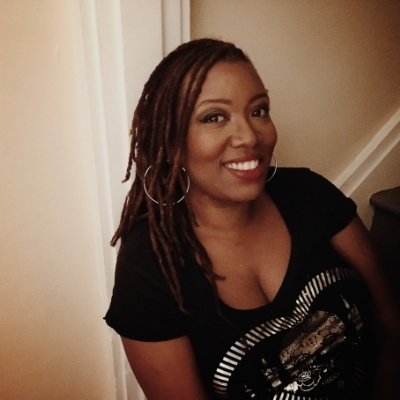 Headshot of author Deesha Philyaw, a Black woman wearing hoop earrings and a black graphic t-shirt
