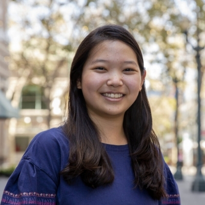 Headshot of author K-Ming Chang, a smiling Asian woman wearing a blue top