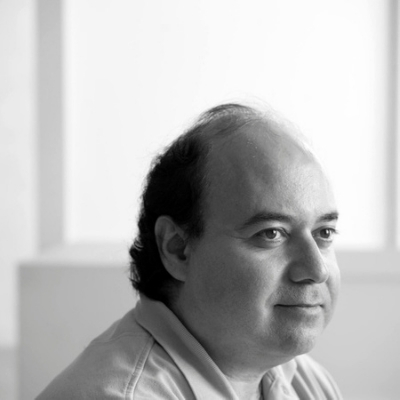 Black and white headshot of author Osama Alomar, an Arab man wearing a collared shirt