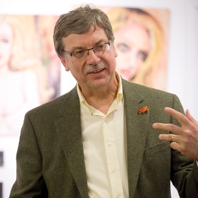 Headshot of author Steve Wiegenstein, a White man with glasses and a moustache wearing a collared shirt and blazer