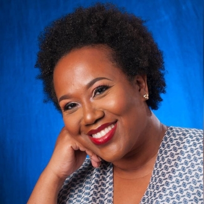 Headshot of author Cherie Jones, a person smiling at the camera wearing red lipstick and a patterned top