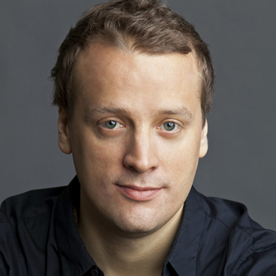 Headshot of Charles Finch, a White man wearing a dark top