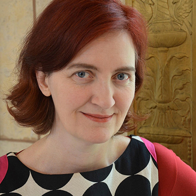 Headshot of author Emma Donoghue, a White woman with red hair and a colorful top