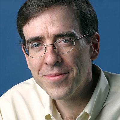 Headshot of Ron Charles, a White man wearing glasses and a light collared top