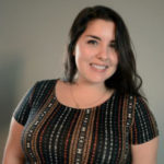 Headshot of Adriana Thornton, a Latin woman with long dark hair wearing a colorful patterned shirt