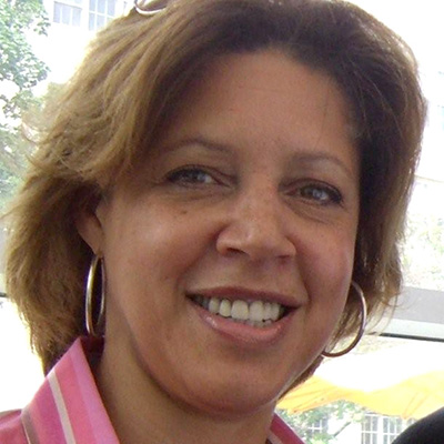 Headshot of Lisa Page, a Black woman wearing hoop earrings and a pink top